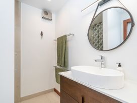 A bathroom with a vanity sink and mirror at Tairua Holiday Home in Tairua