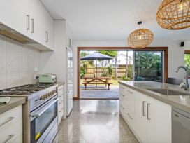 A kitchen with a cooktop and refrigerator at Tairua Holiday Home in Tairua
