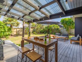 An outdoor patio with table and seating at Tairua Holiday Home in Tairua