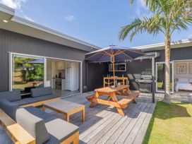 An outdoor area with seating and dining furniture at Tairua Holiday Home in Tairua