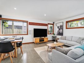 A living room with a sofa and television at Tairua Holiday Home in Tairua
