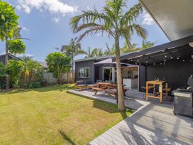 A garden with a wooden table and chairs at Tairua Holiday Home in Tairua
