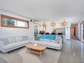 A living room with a sofa and coffee table at Tairua Holiday Home in Tairua