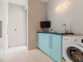 A laundry room with a washing machine and sink at Auckland Holiday Home in Auckland