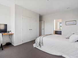 A bedroom with a bed and television at Auckland Holiday Home in Auckland