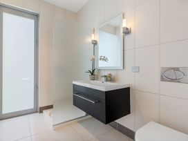 A bathroom with a wash basin and a mirror at Auckland Holiday Home in Auckland