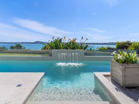 A swimming pool with water feature and ocean view at Auckland Holiday Home in Auckland