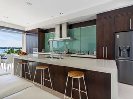 A kitchen with a large island and bar stools at Auckland Holiday Home in Auckland