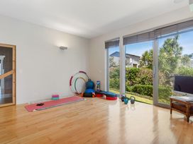 A gym with fitness equipment and large windows at Auckland Holiday Home in Auckland