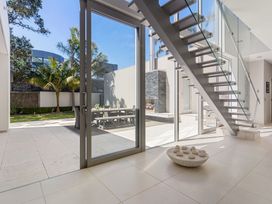 A view of stairs and glass door to outdoor seating area at Auckland Holiday Home in Auckland