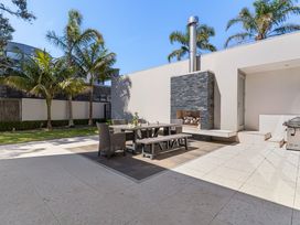 A garden with a patio table and chairs at Auckland Holiday Home in Auckland