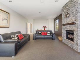 A living room with sofas and a fireplace at Auckland Holiday Home in Auckland