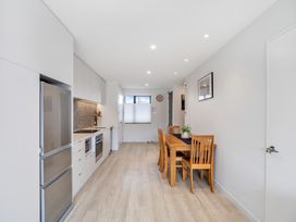 A kitchen with a dining table and chairs at Christchurch Holiday Apartment in Christchurch