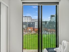 A balcony view of buildings and grass at Christchurch Holiday Apartment in Christchurch