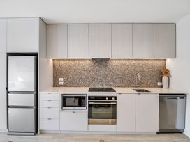 A kitchen with appliances and cabinets at Christchurch Holiday Apartment in Christchurch