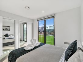 A bedroom with a bed and a mirror at Christchurch Holiday Apartment in Christchurch