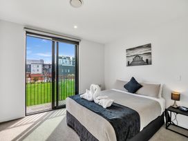 A bedroom with a bed and window at Christchurch Holiday Apartment in Christchurch