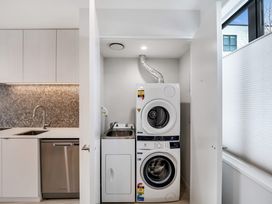 A laundry room with washing machine and dryer at Christchurch Holiday Apartment Christchurch
