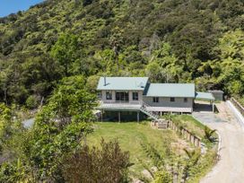 A house with a green roof and deck surrounded by trees and bushes at Picton