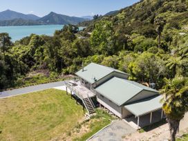 An aerial view of a house with a deck and lawn by the water at Picton in Picton