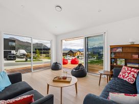 A living room with a sofa and sliding doors at Skiwi - Wanaka Holiday Home Wanaka