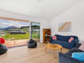 A living room with a sofa and a view at Skiwi - Wanaka Holiday Home in Wanaka