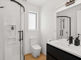 A bathroom with a shower, toilet, and sink at Skiwi - Wanaka Holiday Home in Wanaka