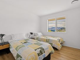 A bedroom with two beds and a window at Skiwi - Wanaka Holiday Home in Wanaka