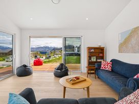 A living room with a sliding door and outdoor view at Skiwi - Wanaka Holiday Home, Wanaka
