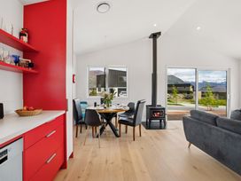 A dining area with a table and chairs near a window at Skiwi - Wanaka Holiday Home in Wanaka