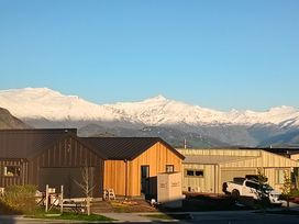 A view of houses and snow-capped mountains at Skiwi - Wanaka Holiday Home in Wanaka