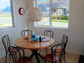 A dining room with a round table and chairs at Skiwi - Wanaka Holiday Home Wanaka
