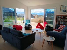A living room with a sofa and bean bags at Skiwi - Wanaka Holiday Home, Wanaka