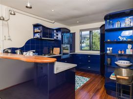 A kitchen with blue cabinets and wooden counter at Ruakaka in Ruakaka