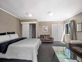 A bedroom with a bed and sofa at Lakepath Retreat - Lake Rotoiti Holiday Home Rotoiti Forest