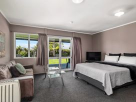 A bedroom with a bed and sliding door leading to outdoor area at Lakepath Retreat - Lake Rotoiti Holiday Home Rotoiti Forest
