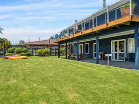 A garden with kayaks and seating area at Lakepath Retreat - Lake Rotoiti Holiday Home