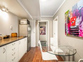 A kitchen with a dining table and refrigerator at Lakepath Retreat - Lake Rotoiti Holiday Home, Rotoiti Forest