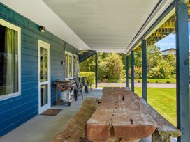 An outdoor patio with a wooden table and chairs at Lakepath Retreat - Lake Rotoiti Holiday Home Rotoiti Forest