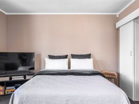 A bedroom with a bed and television at Lakepath Retreat - Lake Rotoiti Holiday Home