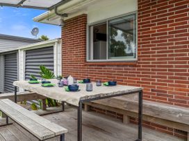 An outdoor dining area with a table set for a meal at Rotoiti Escape - Lake Rotoiti Holiday Home