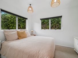 A bedroom with a bed and windows at Rotoiti Escape - Lake Rotoiti