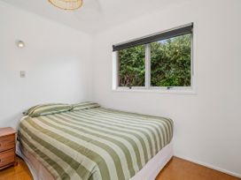 A bedroom with a bed and window at Rotoiti Escape - Lake Rotoiti