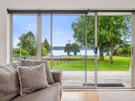 A living room with a view of a lake and trees at Rotoiti Escape - Lake Rotoiti Holiday Home