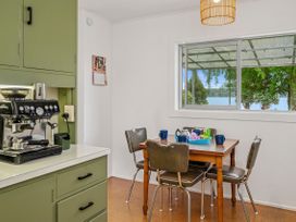 A kitchen with a dining table and coffee machine at Rotoiti Escape - Lake Rotoiti