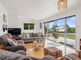 A living room with a sofa and television at Rotoiti Escape - Lake Rotoiti Holiday Home