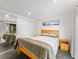 A bedroom with a bed and bedside table at Lake Taupo Holiday Home in Motuoapa