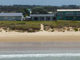 Houses by a beach with a pathway leading down to the sand at Karikari in Kaitaia
