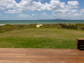 A view of the ocean and grass from a deck at Karikari in Kaitaia