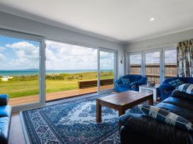 A living room with a view of the sea at Karikari in Kaitaia
